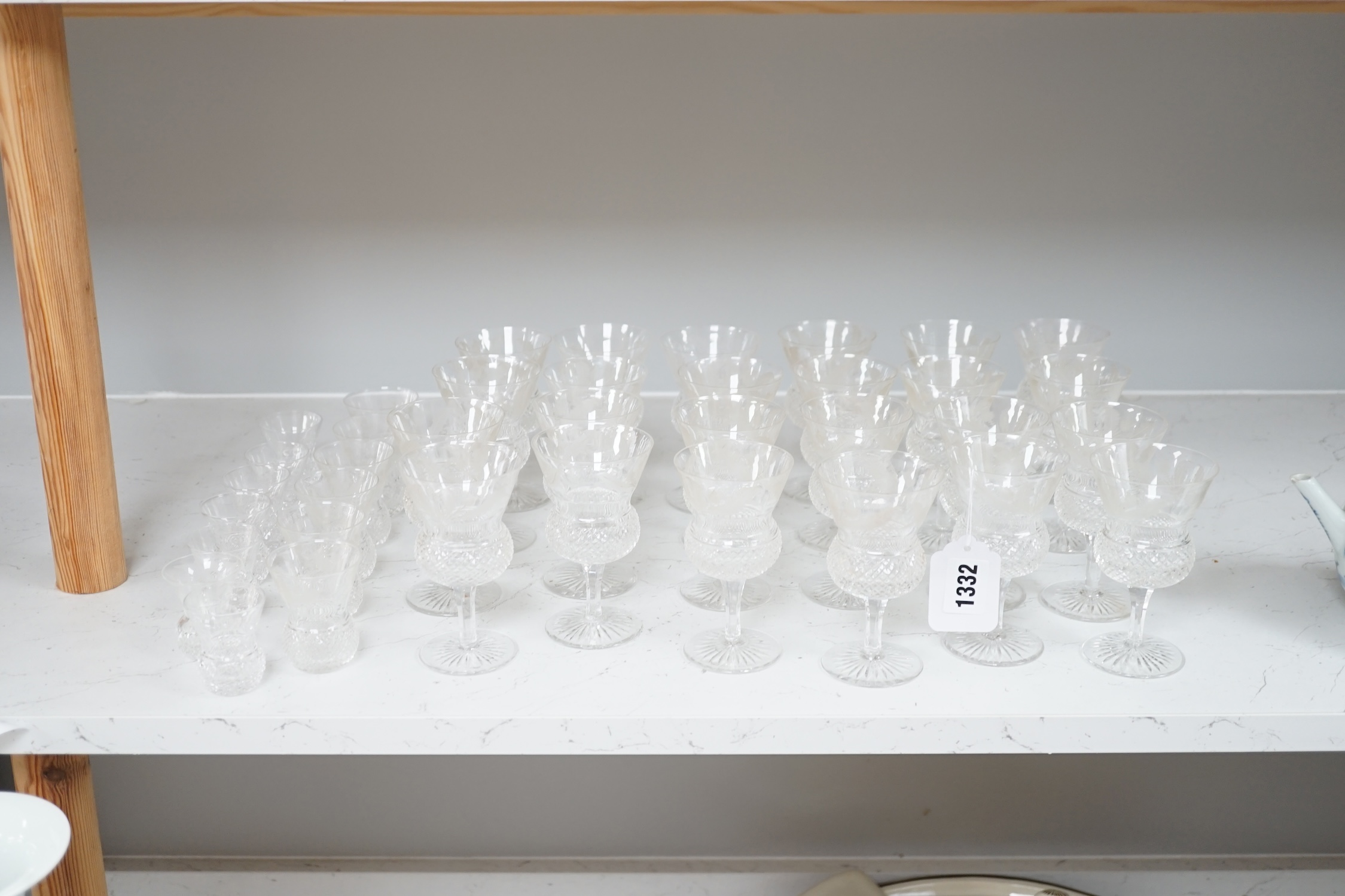 A set of twenty four Edinburgh cut glass thistle glasses and thirteen assorted smaller examples, largest 12cm high. Condition - mostly good